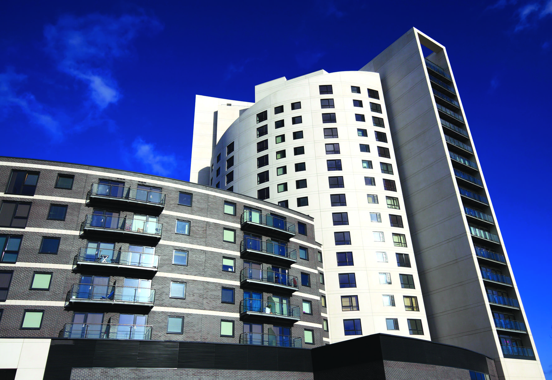 67bf58a2b5378_wormald-strata-building A group of buildings with windows and balconies.